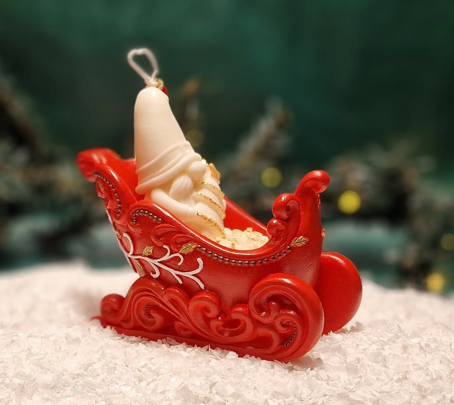 Handgemachte Sojawachskerze mit einem weißen Weihnachtsmann in reich verzierten roten Weihnachtsschlitten. Handgemachte Sojawachskerze mit einem weißen Weihnachtsmann in reich verzierten roten Weihnachtsschlitten.