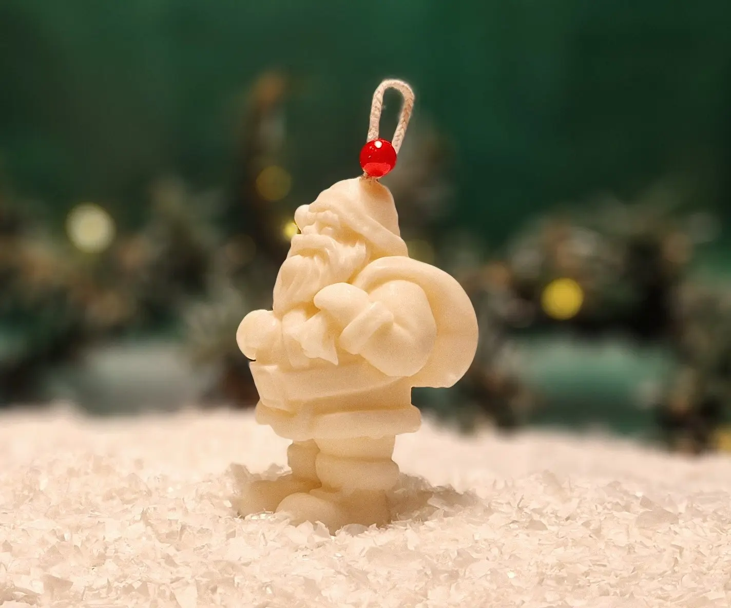 Ręcznie robiona świeca sojowa w kształcie białego Mikołaja, ozdobiona czerwonym koralikiem na sznurku