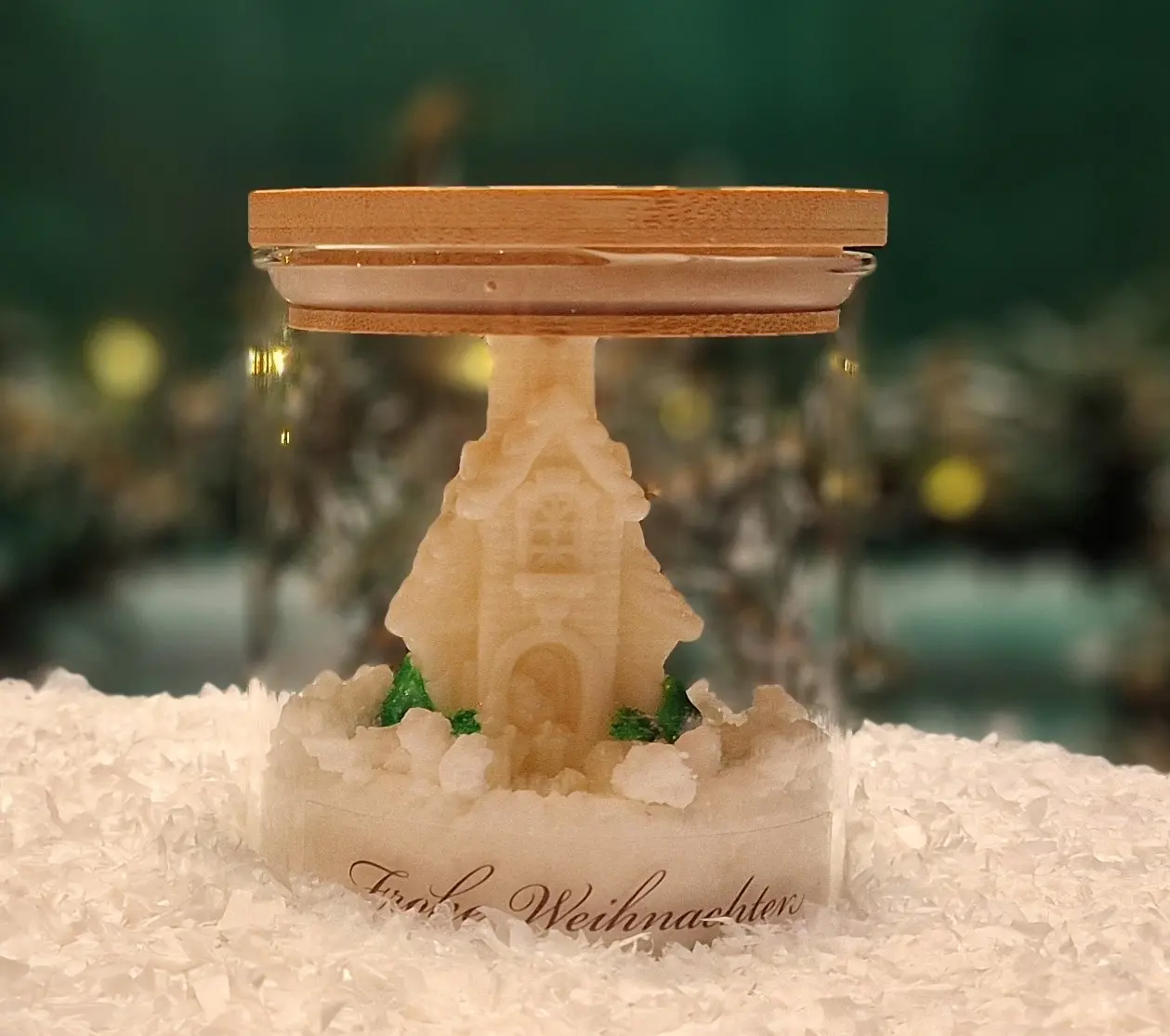 Handmade soy wax candle shaped like a winter cottage, placed in a glass jar with a wooden lid and the inscription ‘Frohe Weihnachten’. Handmade soy wax candle shaped like a winter cottage, placed in a glass jar with a wooden lid and the inscription ‘Frohe Weihnachten’.