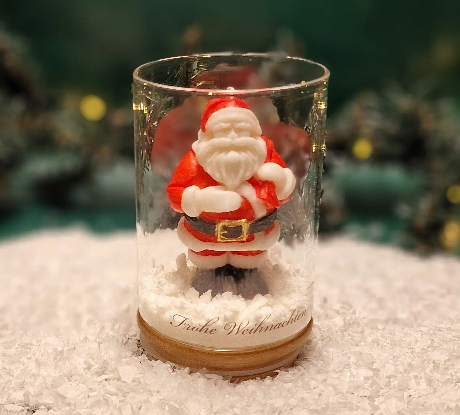 Handgemachte Sojawachskerze in Form eines Weihnachtsmanns in einem Glas mit Holzdeckel und dem Schriftzug ‘Frohe Weihnachten’