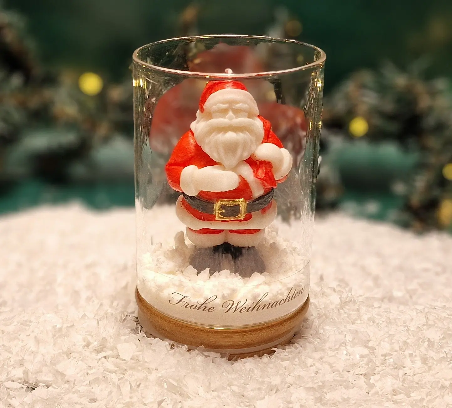 Handgemachte Sojawachskerze in Form eines Weihnachtsmanns in einem Glas mit Holzdeckel und dem Schriftzug ‘Frohe Weihnachten’