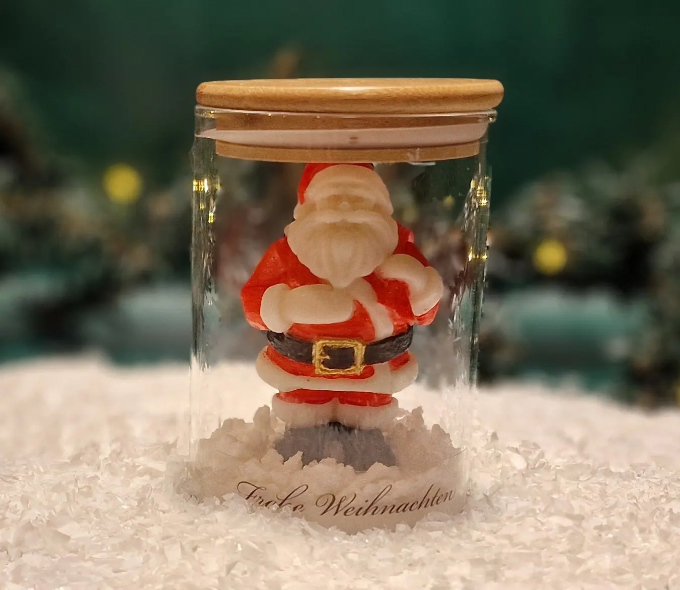 Handgemachte Sojawachskerze in Form eines Weihnachtsmanns in einem Glas mit Holzdeckel und dem Schriftzug ‘Frohe Weihnachten’