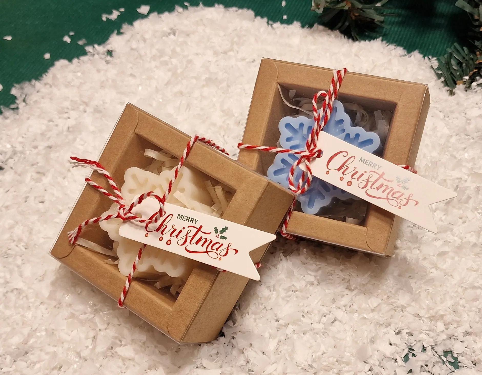 Ręcznie robione świąteczne świeczki sojowe w kształcie płatków śniegu, zapakowane w ekologiczne pudełka z etykietą ‘Merry Christmas’
