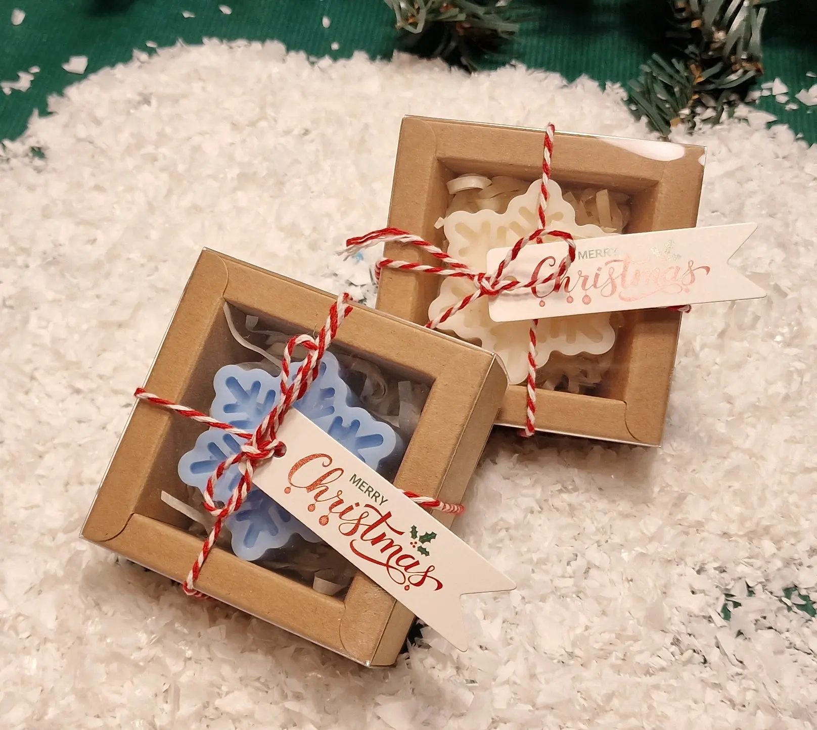 Ręcznie robione świąteczne świeczki sojowe w kształcie płatków śniegu, zapakowane w ekologiczne pudełka z etykietą ‘Merry Christmas’