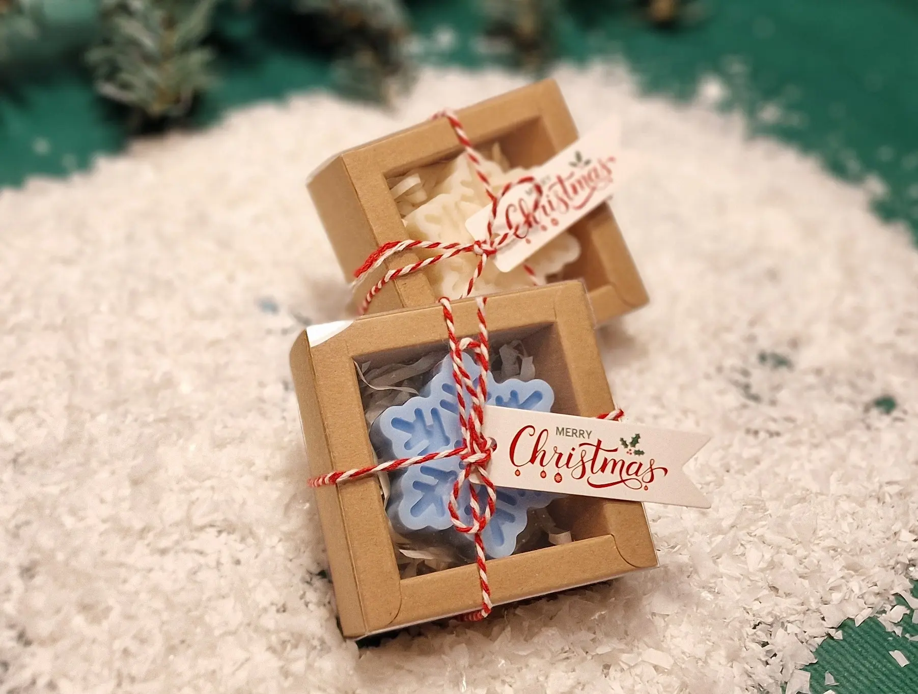 Ręcznie robione świąteczne świeczki sojowe w kształcie płatków śniegu, zapakowane w ekologiczne pudełka z etykietą ‘Merry Christmas’