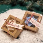 Ręcznie robione świąteczne świeczki sojowe w kształcie płatków śniegu, zapakowane w ekologiczne pudełka z etykietą ‘Merry Christmas’