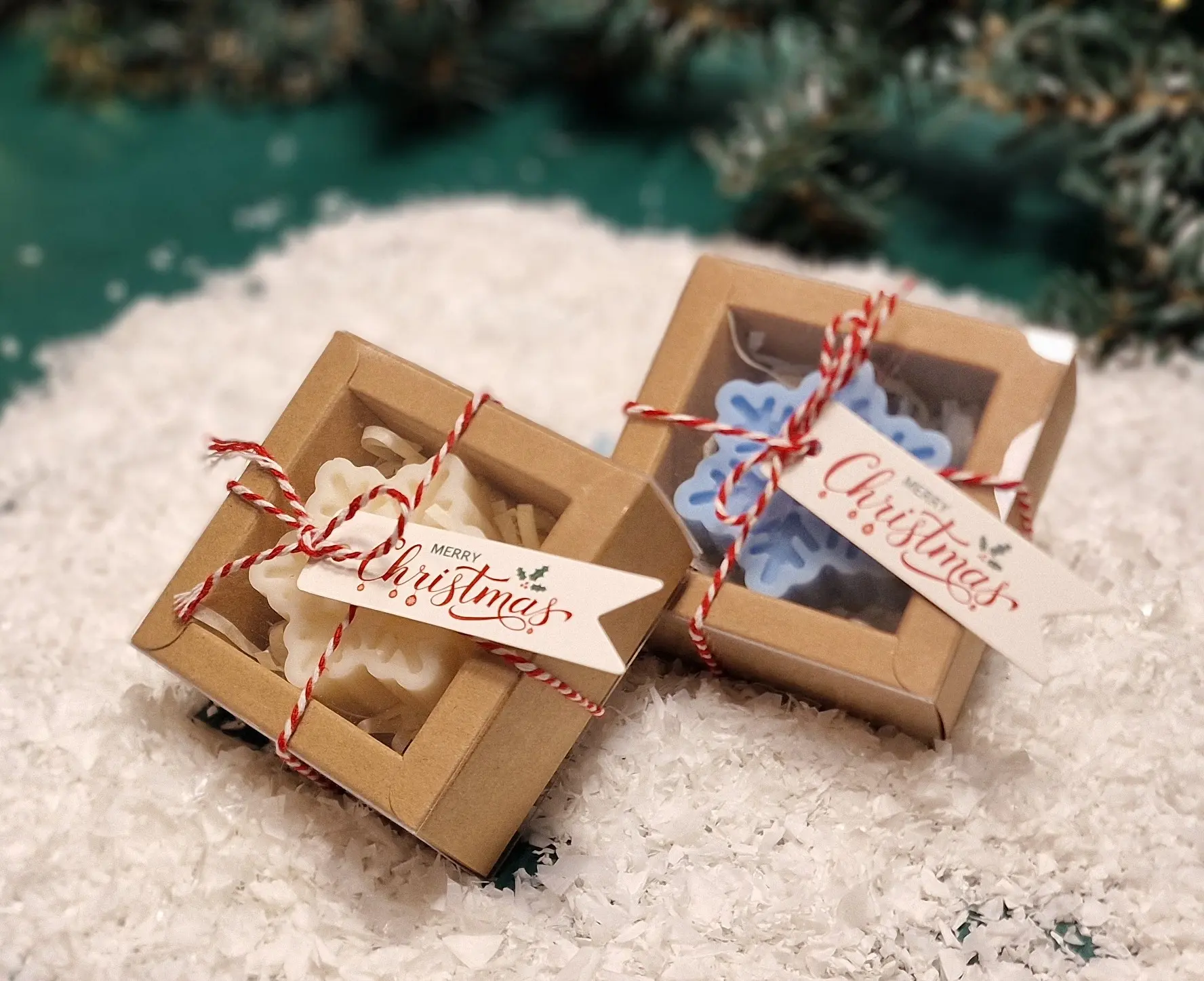 Ręcznie robione świąteczne świeczki sojowe w kształcie płatków śniegu, zapakowane w ekologiczne pudełka z etykietą ‘Merry Christmas’