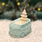 Handgemachte kupferfarbene Sojawachskerze in Form eines 2025-Busses mit einem weißen Tannenbaum als Docht