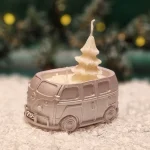 Handgemachte kupferfarbene Sojawachskerze in Form eines 2025-Busses mit einem weißen Tannenbaum als Docht
