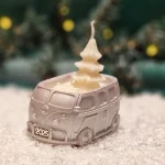 Handgemachte kupferfarbene Sojawachskerze in Form eines 2025-Busses mit einem weißen Tannenbaum als Docht