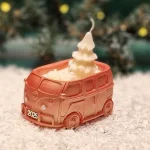 Handgemachte kupferfarbene Sojawachskerze in Form eines 2025-Busses mit einem weißen Tannenbaum als Docht