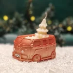 Handgemachte kupferfarbene Sojawachskerze in Form eines 2025-Busses mit einem weißen Tannenbaum als Docht