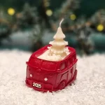 Handgemachte rote Sojawachskerze in Form eines 2025-Busses mit einer weißen Tannenbaumkerze als Docht